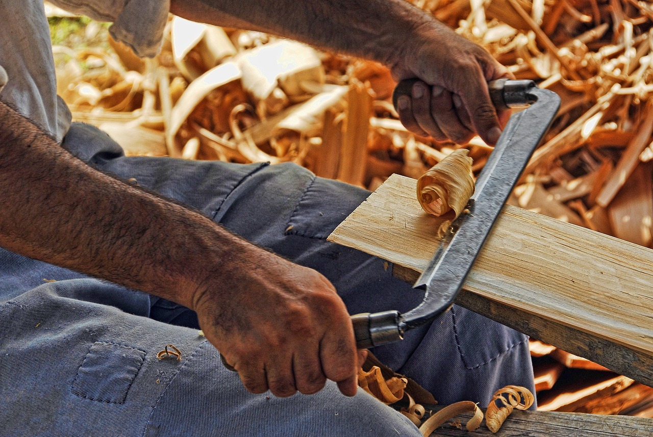 Hands shaving timber with a plane